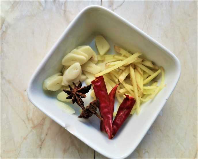 Cut the ginger into shreds, slice the garlic, and remove the seeds from the pepper.