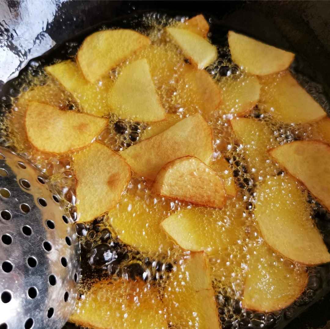 Add oil to the pot, pour in potatoes, fry until the surface turns golden brown, remove and set aside.