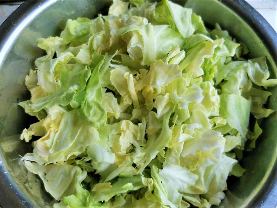 Tear cabbage into pieces of uniform size by hand.