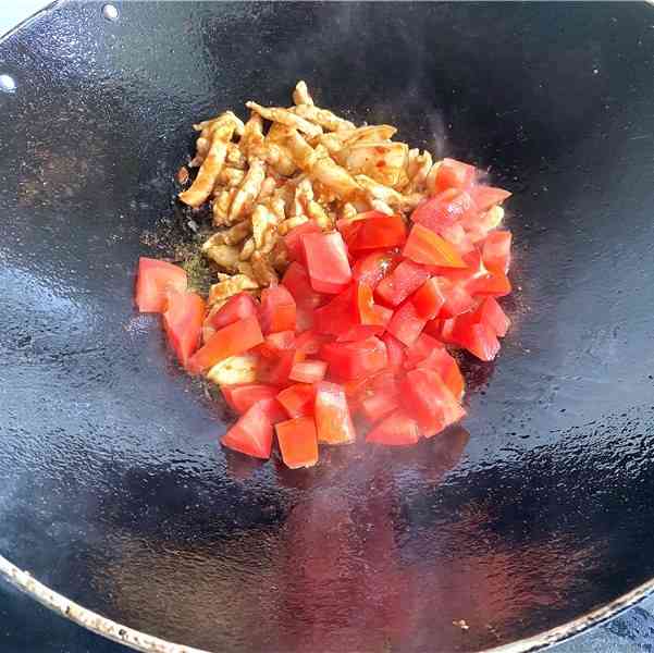 Stir-fry until the pork shreds turns white. Then pour diced tomatoes.