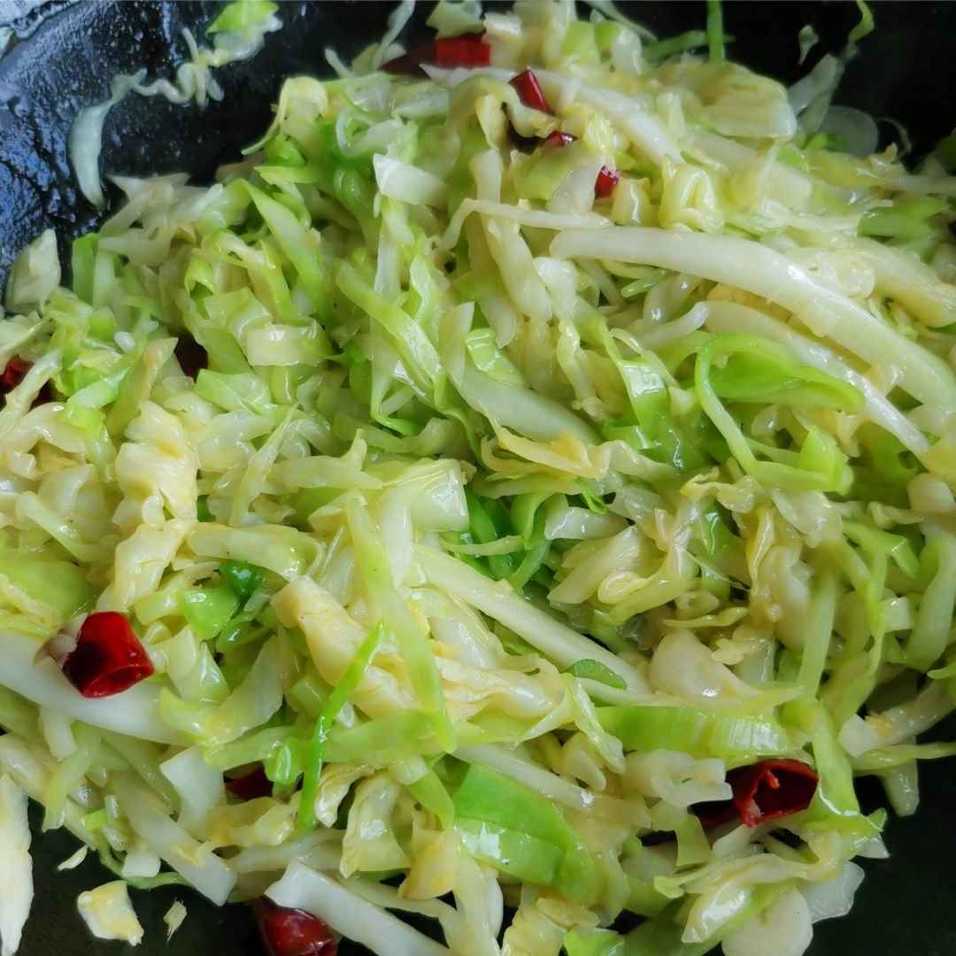 Pour the shredded cabbage and stir-fry over high heat.