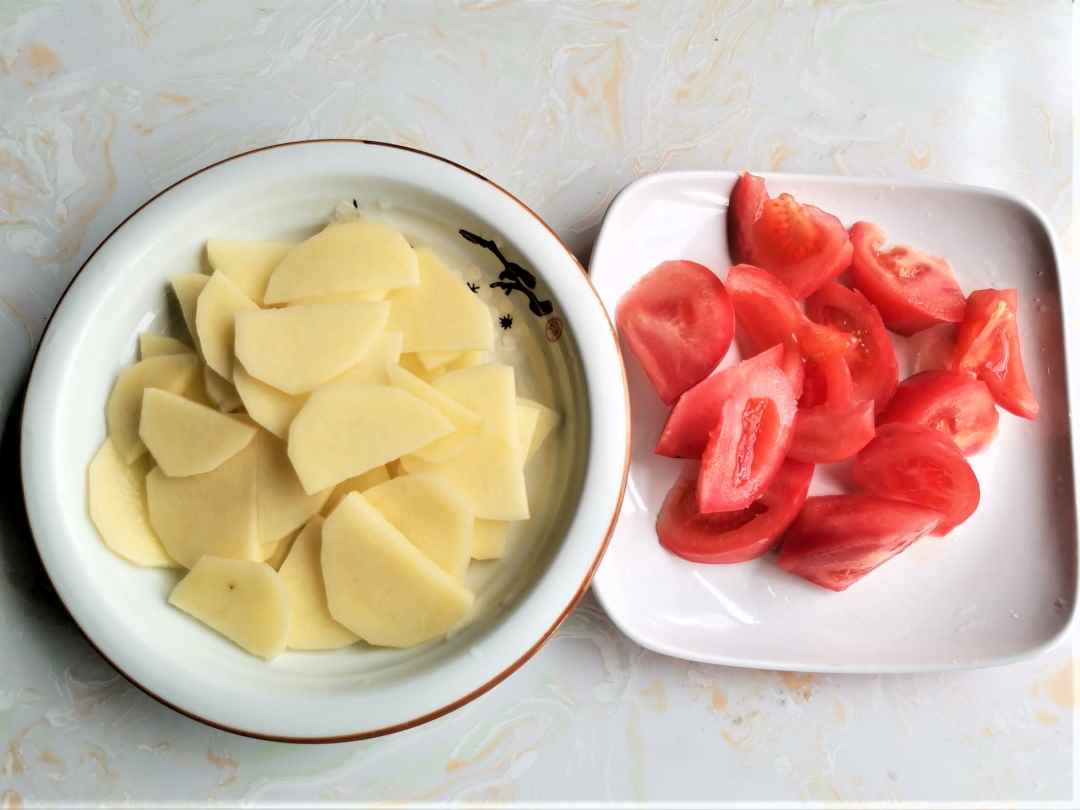 Tomatoes and potatoes are cut into slices.