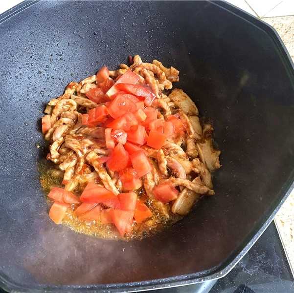 Fry until the shredded pork becomes discolored and pour in the tomatoes.